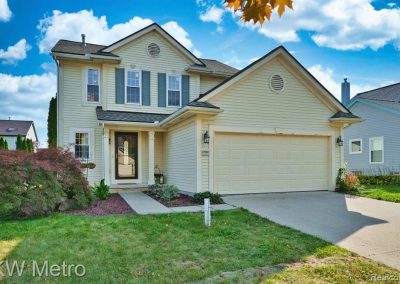Image of a yellow two story home with a front facing garage.
